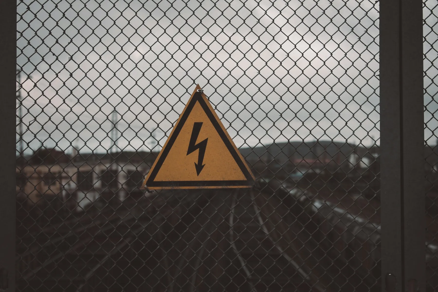Warnschild für Hochspannung an einem Maschendrahtzaun