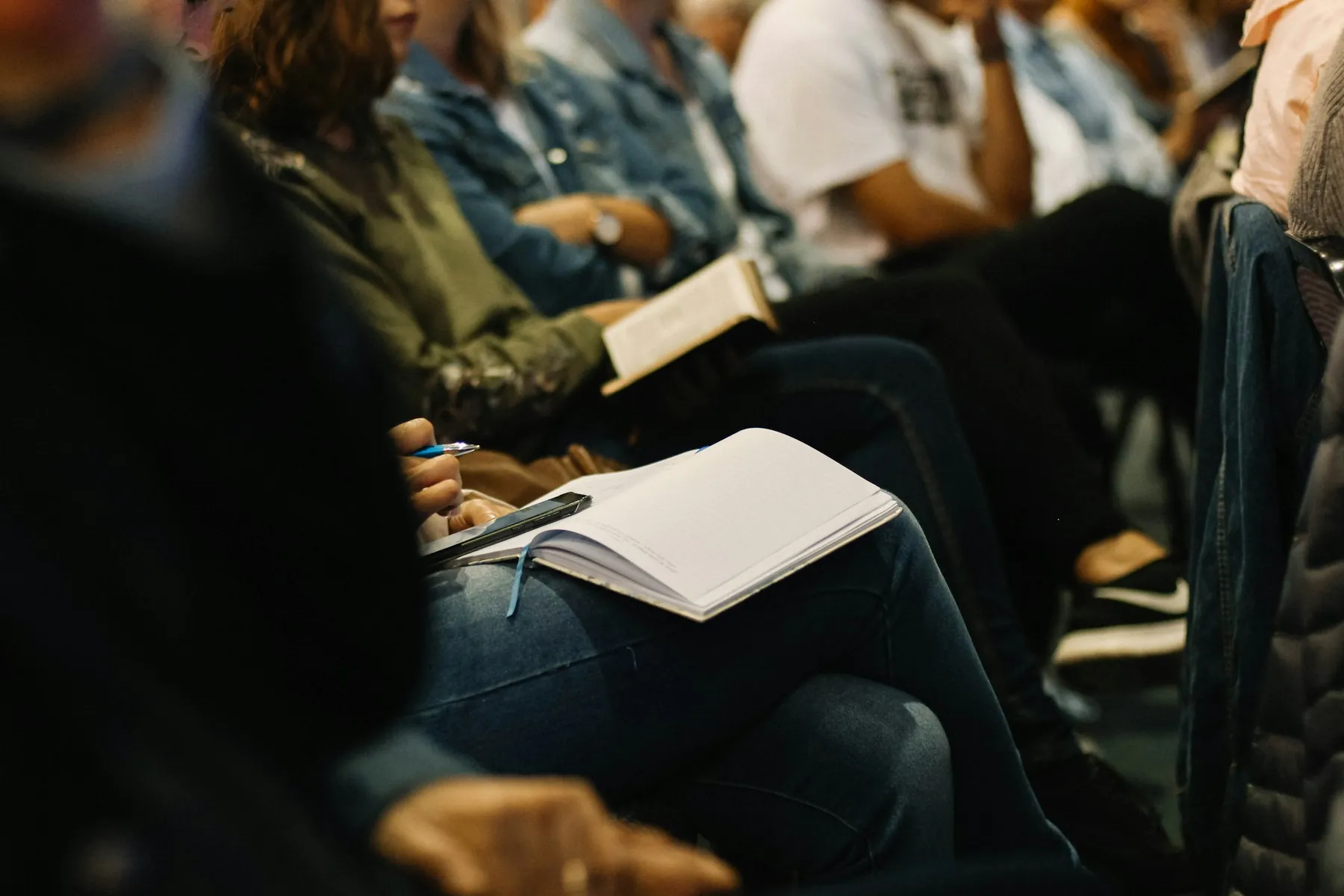 Menschen mit Notizblöcken in einem Seminar